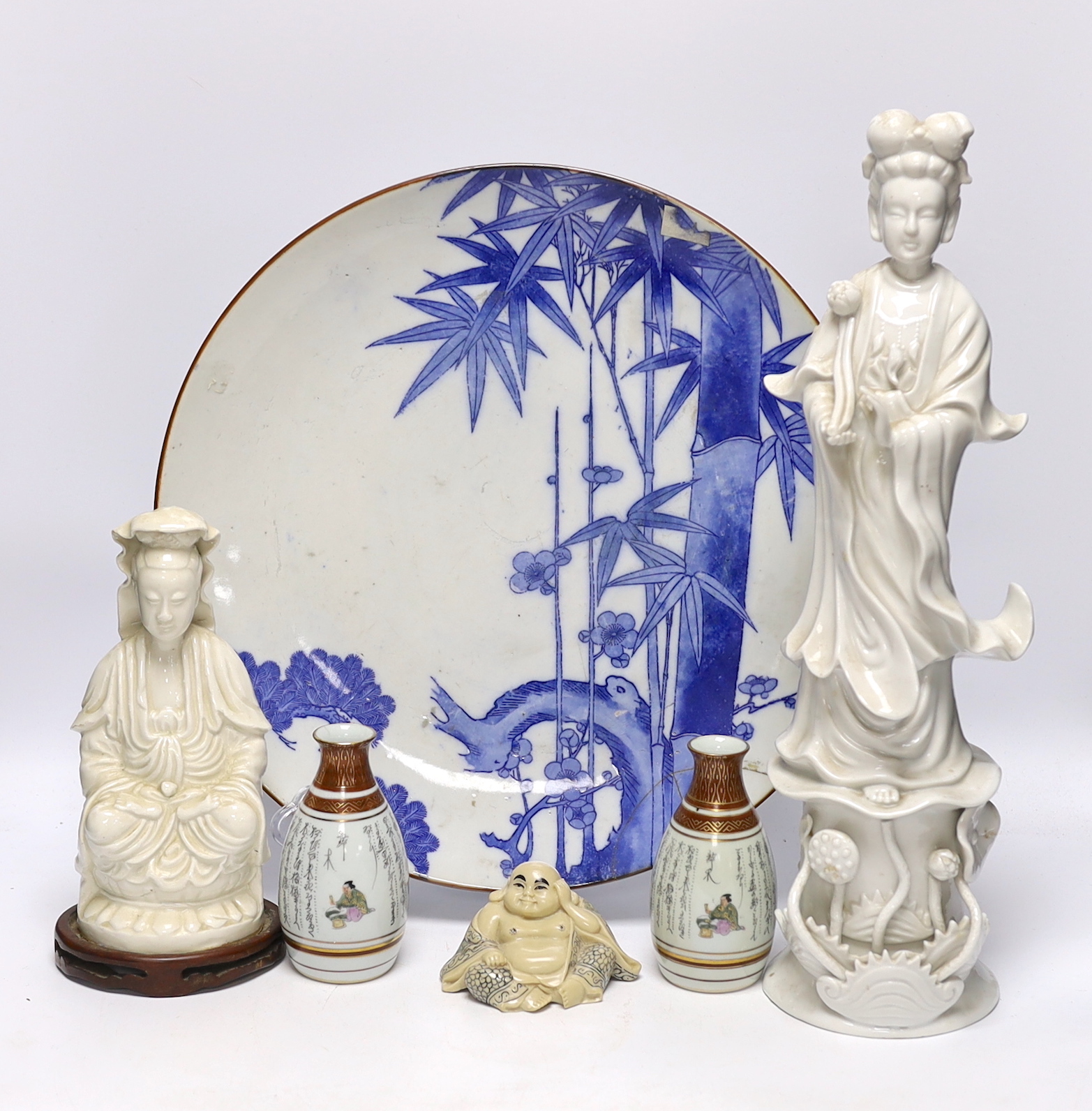 Japanese and Chinese ceramics including blue and white bamboo plate, blanc de chine figures, and Buddha with erotic scene to the base, largest 42cm high